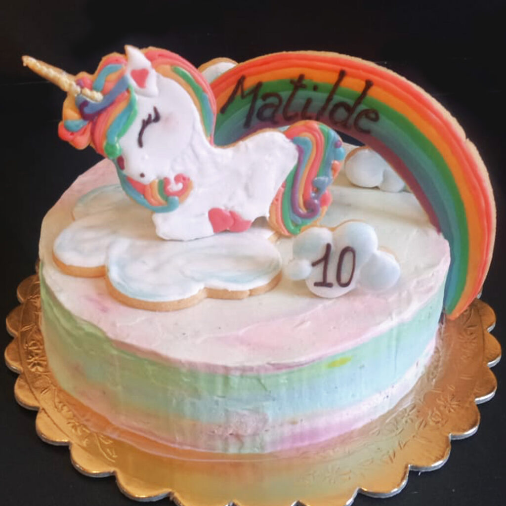 torta con crema e fragole e un bellissimo UNICORNO + arcobaleno in frolla decorati in ghiaccia reale. Copertura panna e mascarpone colorato